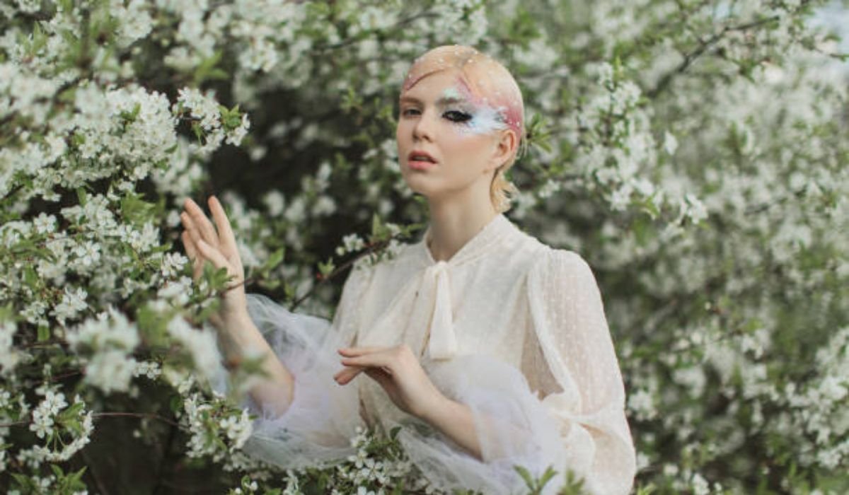 fairycore-fashion-outfit-with-sheer-layering-and-floral-accessories-in-a-forest